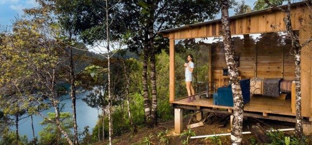 Imagen de resumen del exterior de la cabaña de cristal frente al lago.
